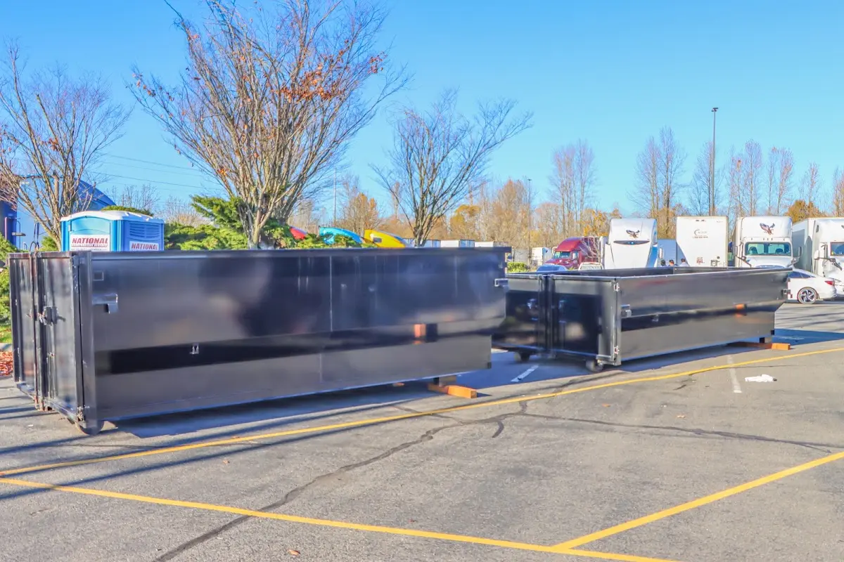 Professional dumpster rental service with roll-off container on residential driveway in Westtown